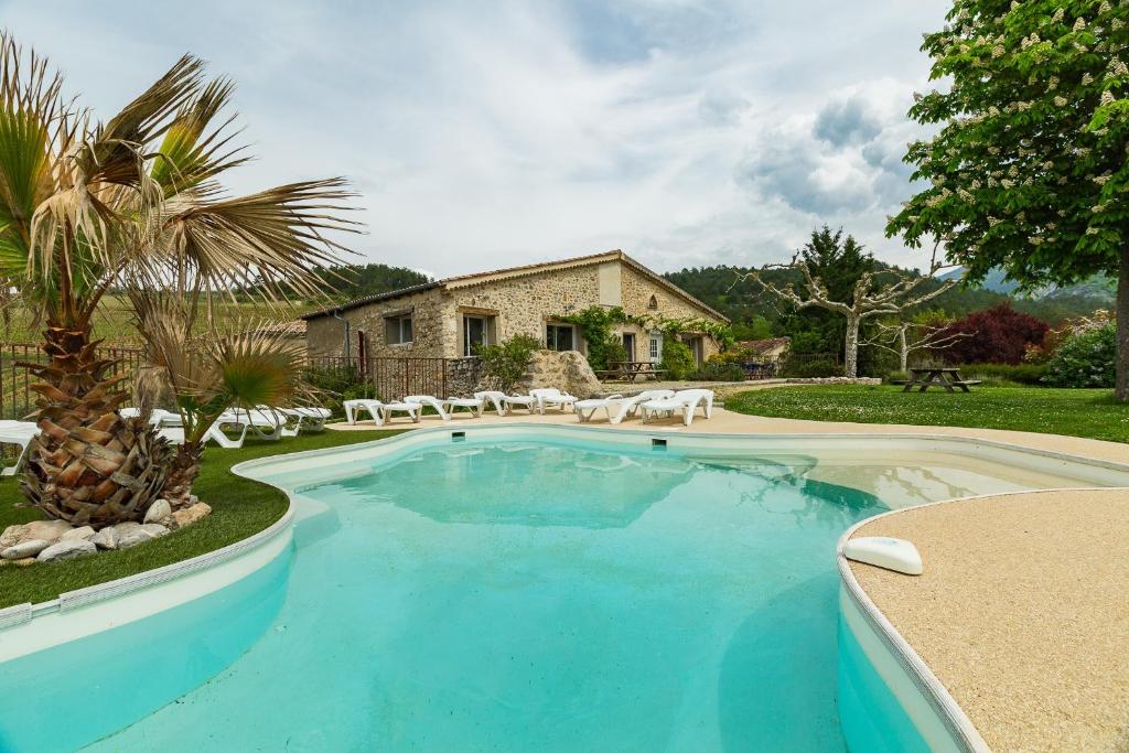 a swimming pool in front of a house at Gîte la Pigne in Aurel