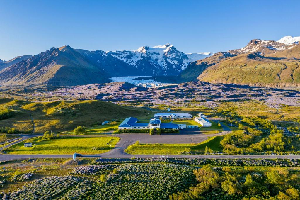 an aerial view of a farm with mountains in the background at Hotel Skaftafell in Skaftafell