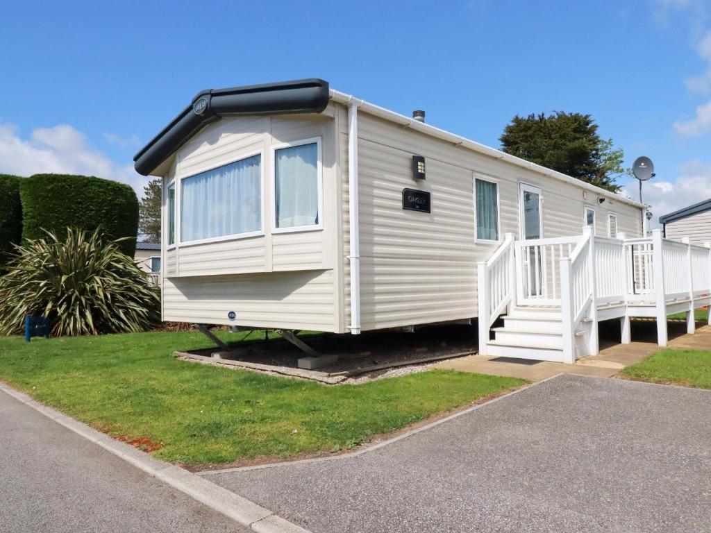 a white mobile home parked in a driveway at The Oakley in Par