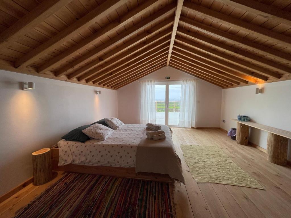 a bedroom with a bed in a room with wooden ceilings at Casa Baía da Lagoa in Lagoa