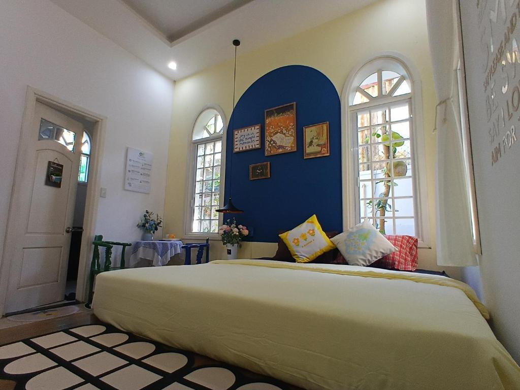a bedroom with a large bed with a blue wall at Green hill side Villa in Cồn Giả Viên
