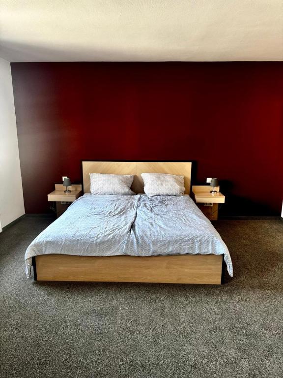 a bedroom with a bed with a red wall at Neros Hotel in Siegenburg