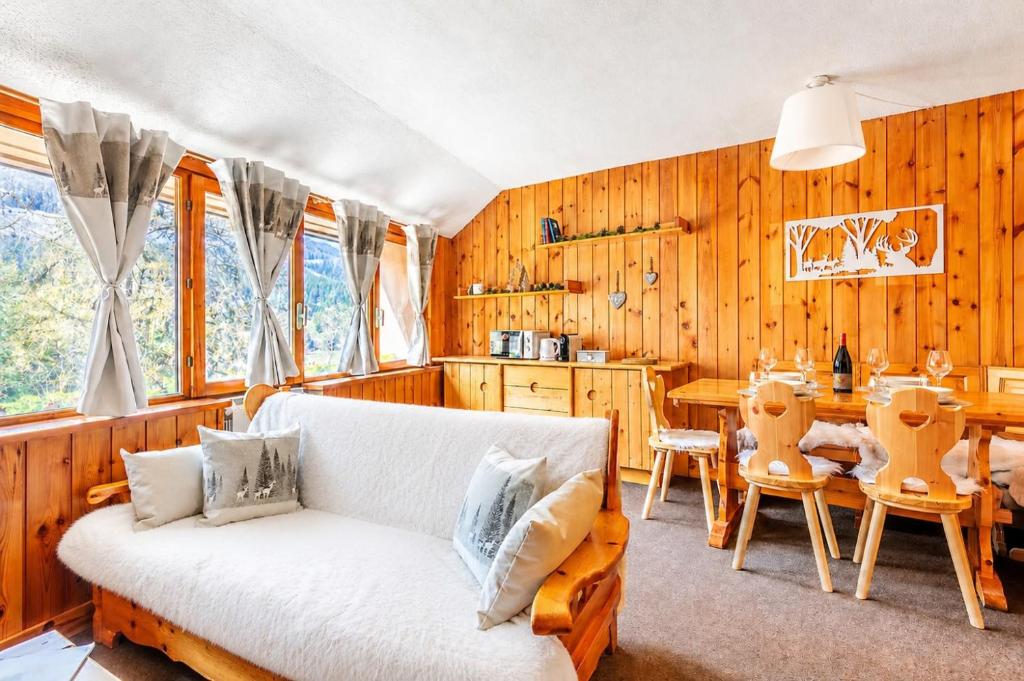 a living room with a white couch and a table at Petit Chalet Pila in Pila