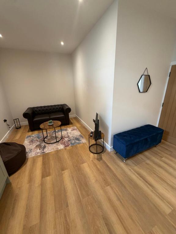 a living room with a couch and a blue ottoman at Windsor Flat 90A in Windsor