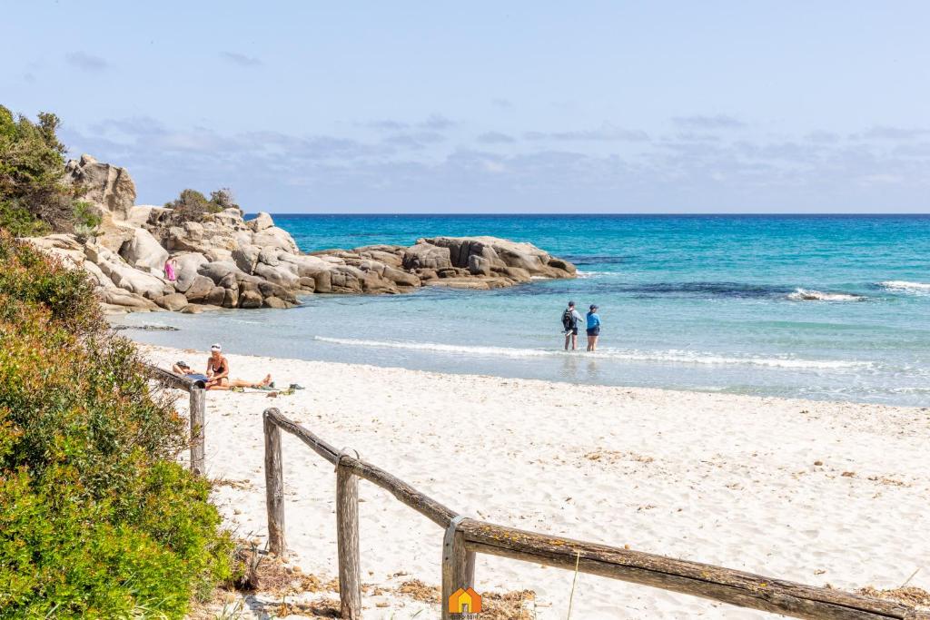 a group of people on a beach near the ocean at Villa Teresa Simius Beach Front in Simius