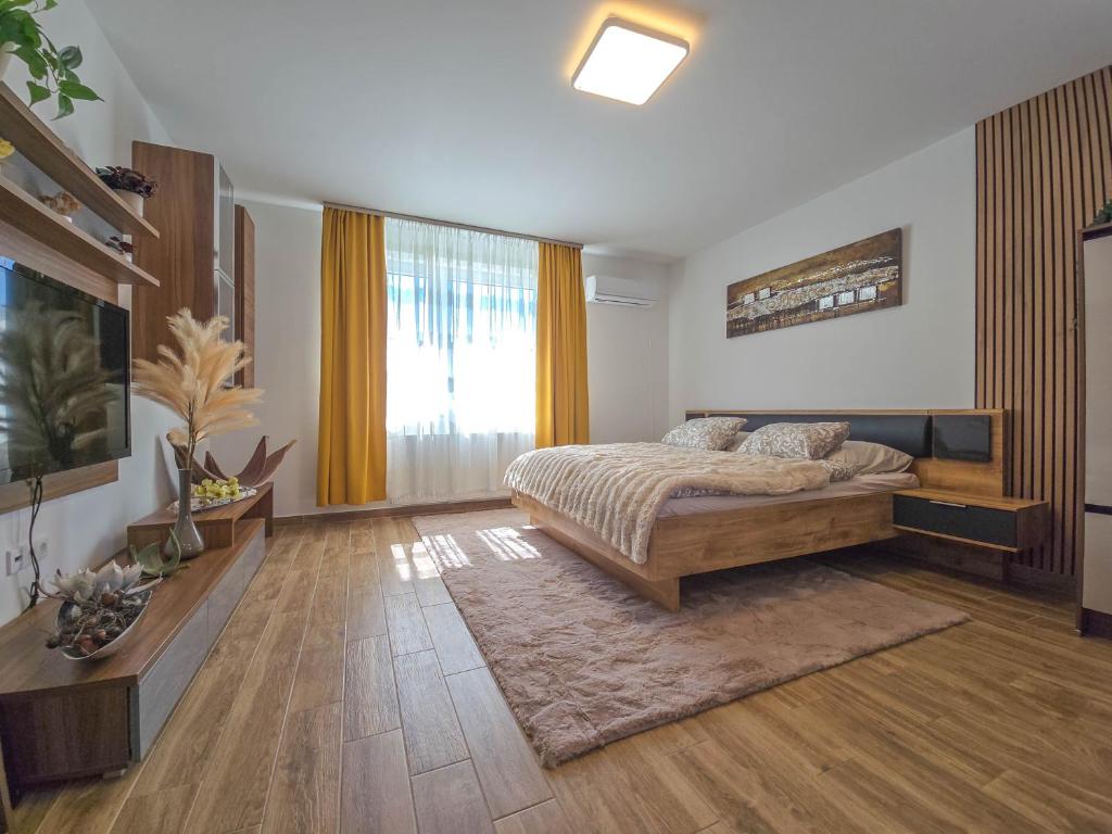 a bedroom with a bed and a large window at Trend Apartman in Bük
