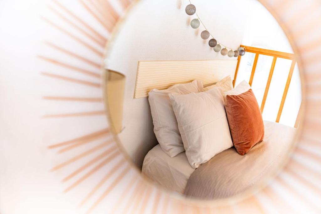 a mirror reflection of a bed with pillows in a room at Mourisco Guest House in Alijó