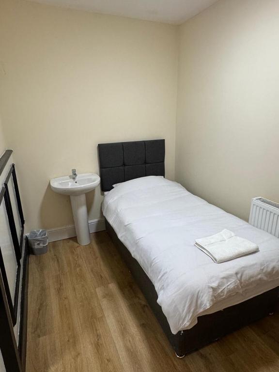 a small bedroom with a bed and a sink at The Dublin Packet- Single Room 7 in Holyhead