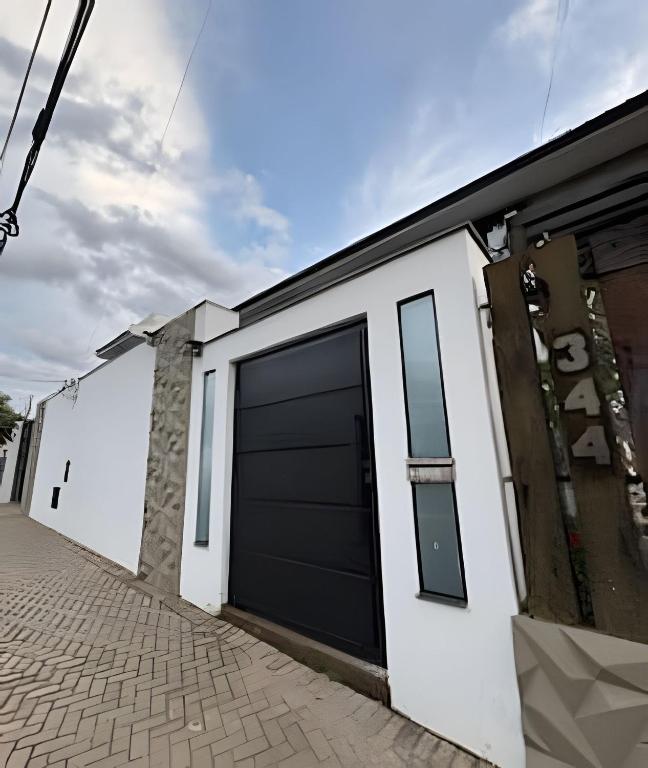 a house with a black garage door on a street at Pousada Carro de Boi in Lavras