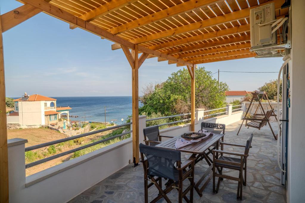 a patio with a table and chairs and the ocean at Sofia's Sea View House in Ágios Dimítrios