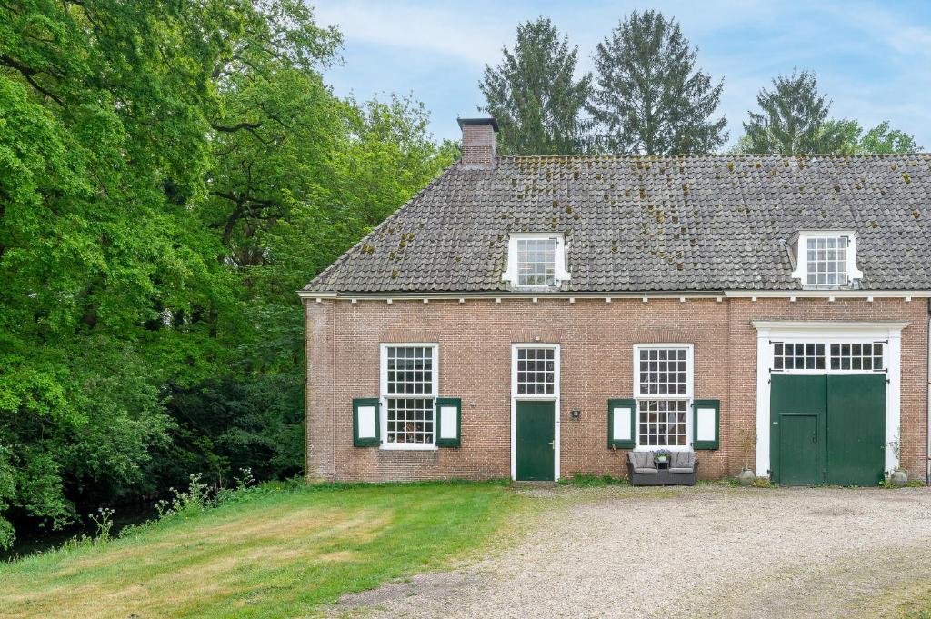 an old brick house with two green doors at Zwaluwenburg 8 in 't Harde