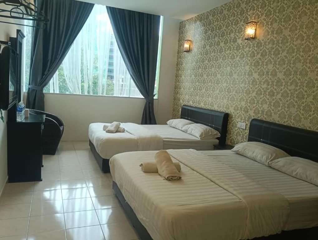 a hotel room with two beds and a window at Hotel Dream Nur Kota Syahbandar in Malacca