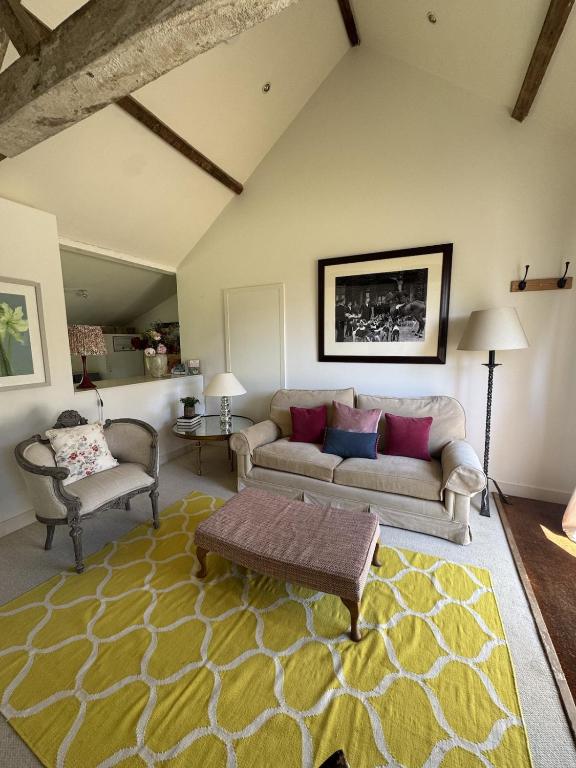 a living room with a couch and two chairs at The Old Barn in Farthinghoe