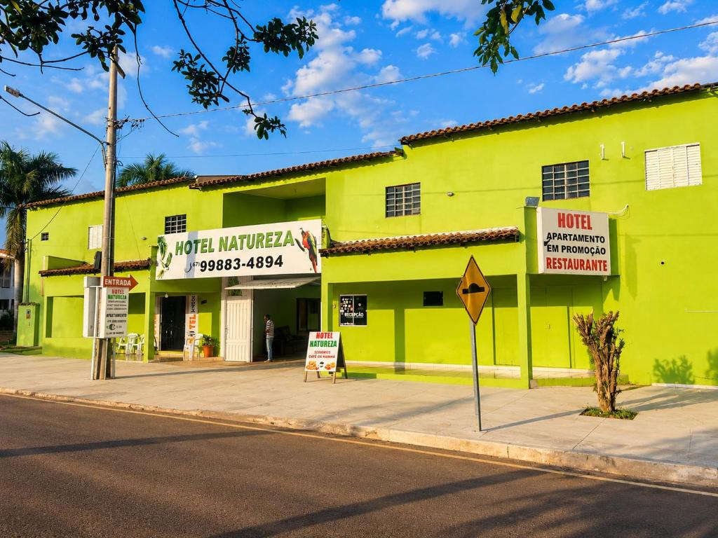 a yellow building on the side of a street at Hotel Natureza in Anhanduí