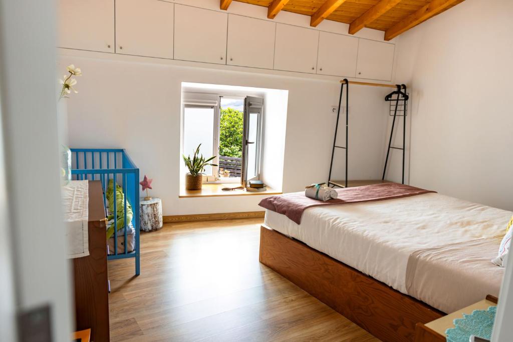 a bedroom with a bed and a window at Viosinho guest house in Alijó