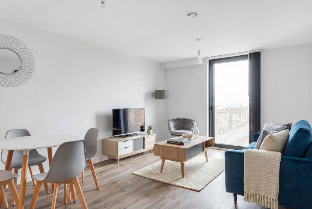 a living room with a blue couch and a table at Central Birmingham 2 BED Modern Spacious Apartment in Birmingham