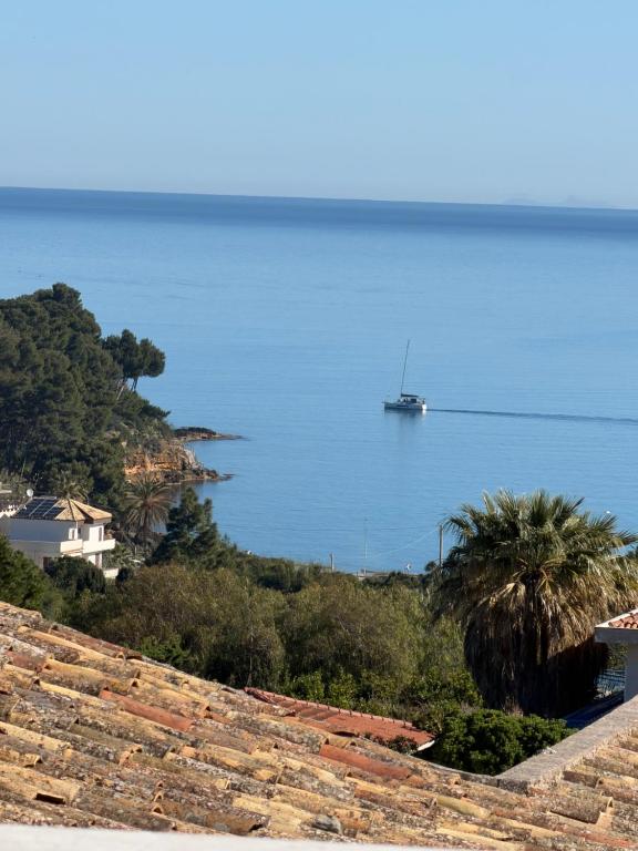 a boat in the water with a view of the ocean at Luxekey ETTORE HOUSE in Scopello