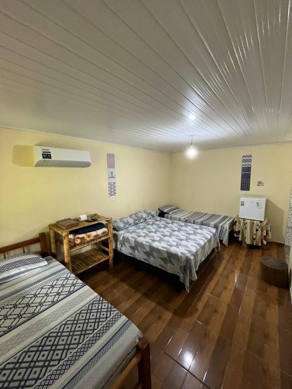 a group of three beds in a room at Pousada Rural João De Barro 1 in Capela Ivapurunduva