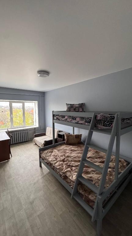 a bedroom with three bunk beds in a room at Хостел in Sumy