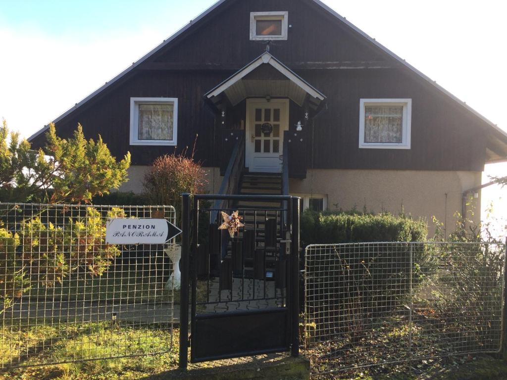 a black house with a gate in front of it at Penzion Panorama in Beroun