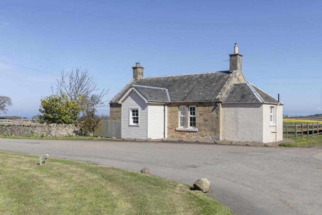 a small white house on the side of a road at Fordel Cottage in Dalkeith