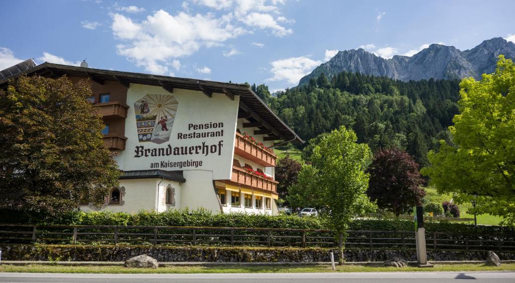 a hotel with a sign on the side of it at Aparthotel Brandauerhof in Walchsee