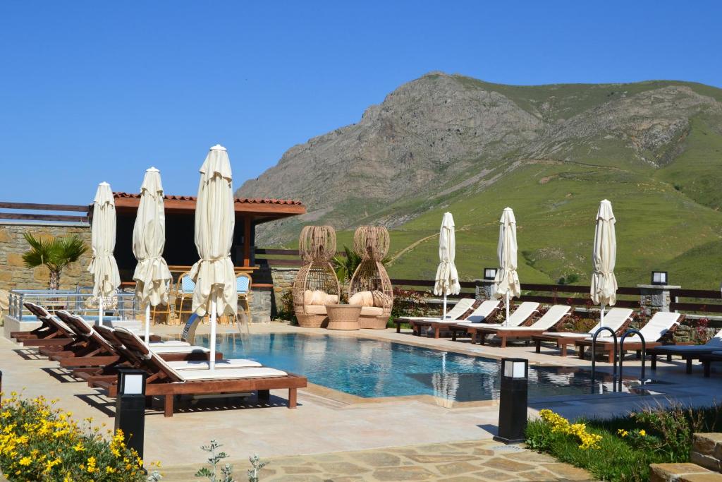 a resort with a pool with chairs and umbrellas at Mathilda Gökçeada in Gokceada Town