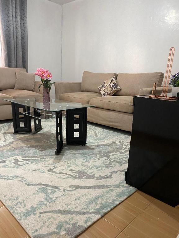 a living room with a couch and a glass table at Suki Ruaka Homes in Ruaka