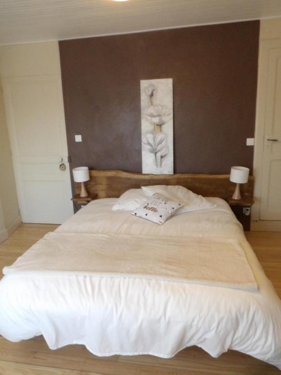 a bedroom with a large white bed with two lamps at Chambre calme Aux Iris in Grandvelle-et-Perrenot