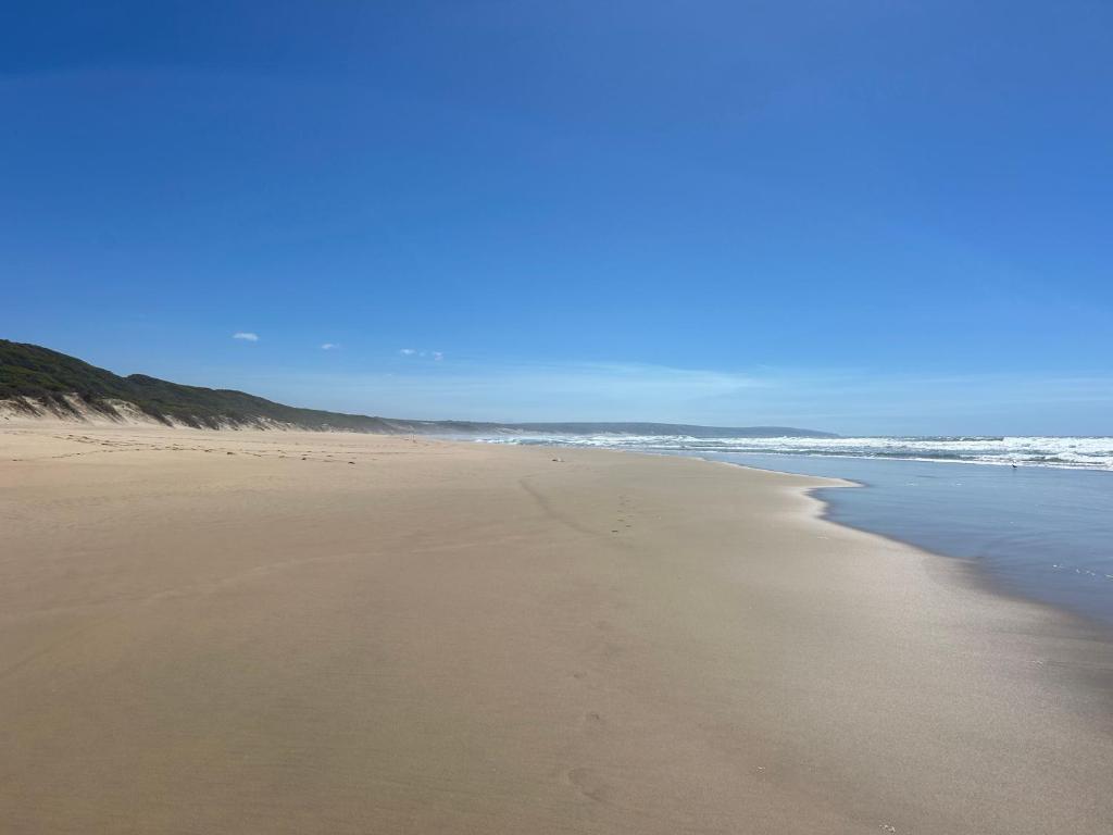 a sandy beach with the ocean in the background at Quill Cottage in Mossel Bay