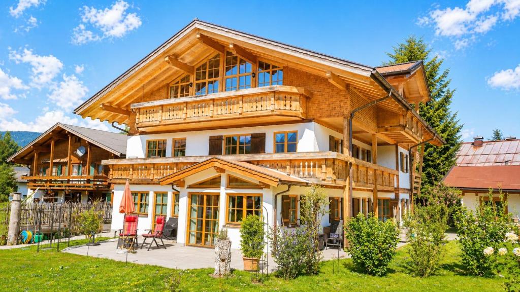 a large wooden house with lots of windows at AlpStern Ferienwohnungen Oberstdorf in Oberstdorf