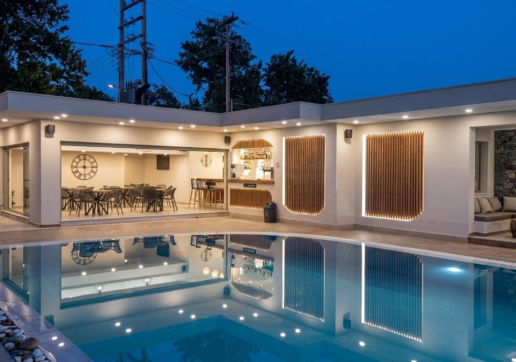 a house with a swimming pool at night at Garden Palace Hotel in Laganas