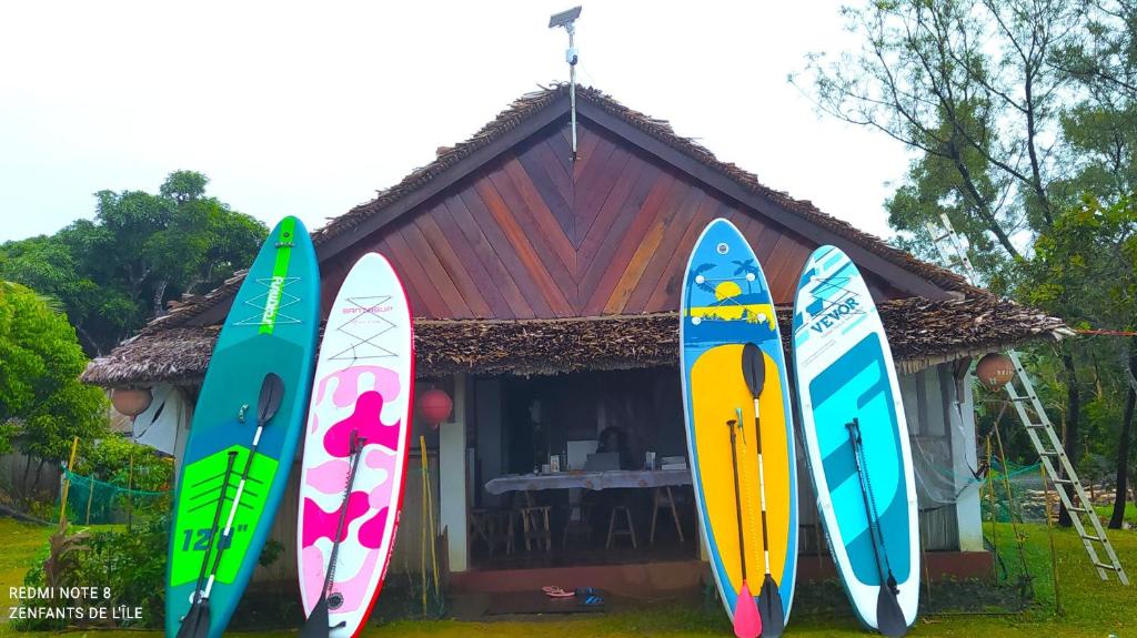 four surfboards are lined up in front of a house at Caban Zenfants in Sainte Marie