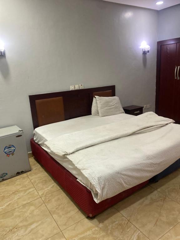 a bedroom with a large bed with white sheets at Hymax Grace hotel in Bolorunpelu