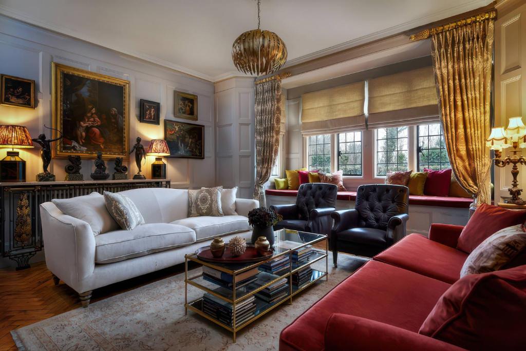 a living room with a white couch and red furniture at Morland Manor in Peterborough
