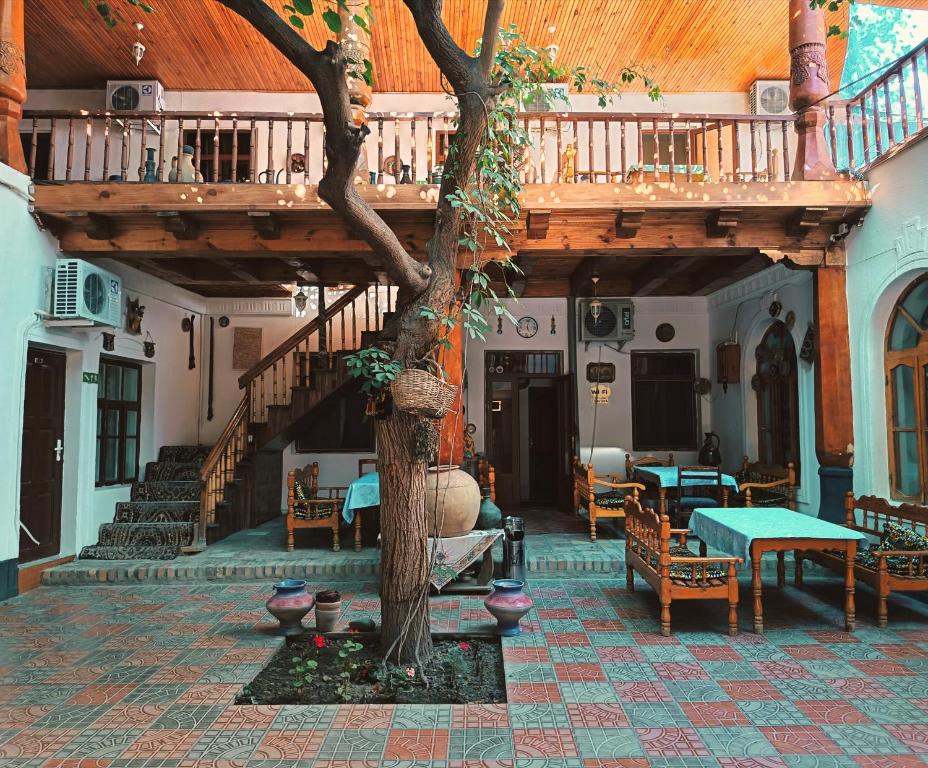 a building with a tree in the middle of a courtyard at Hotel Nazira & Azizbek in Bukhara