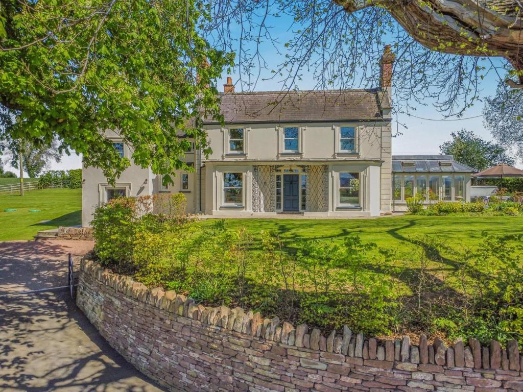 a large white house with a brick wall at 5 Bed in Hereford oc-83658 in Madley