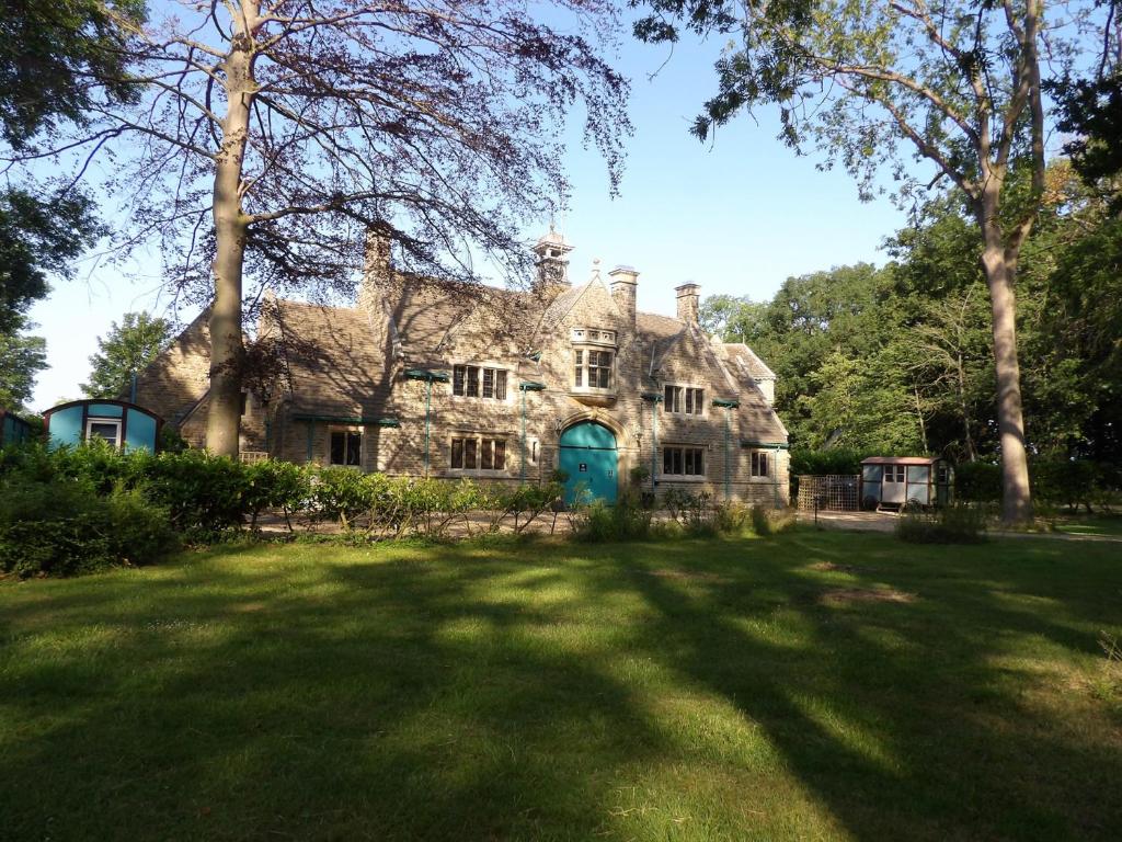 an old house with a green door in a yard at The Lady Rothschild Stables in Peterborough