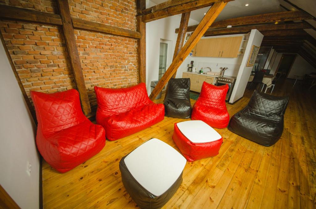 una sala de estar con sillas acolchadas de color rojo y negro. en Mansard in Old Town, en Riga