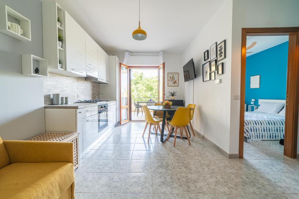 a kitchen and a living room with a table and chairs at Fiordaliso in Alba Adriatica