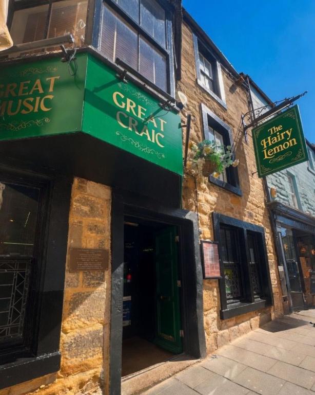 a green sign on the side of a building at The Hairy Lemon in Alnwick