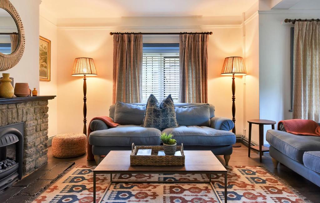 a living room with blue furniture and a fireplace at Home Farm Cottage in Peterborough