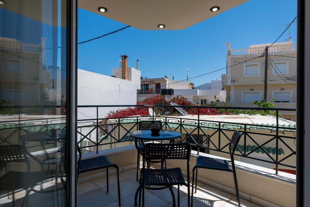 a balcony with chairs and a table and a view at MAREL Luxury Residence Malia in Malia