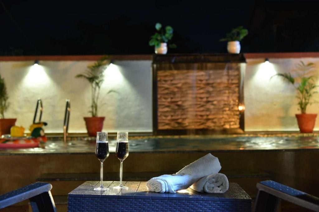 a table with two glasses of wine on it at Sheth lov villa in Lonavala