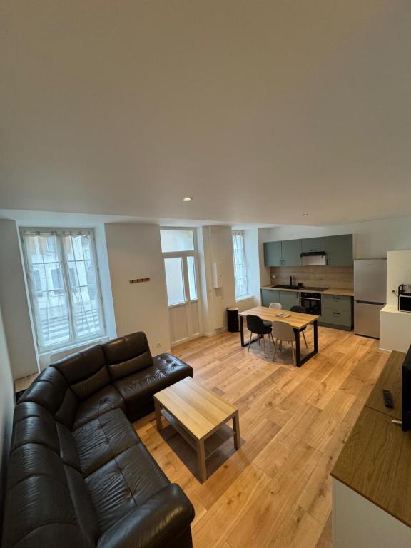 a living room with a couch and a table at L'hotel de ville in Chéroy