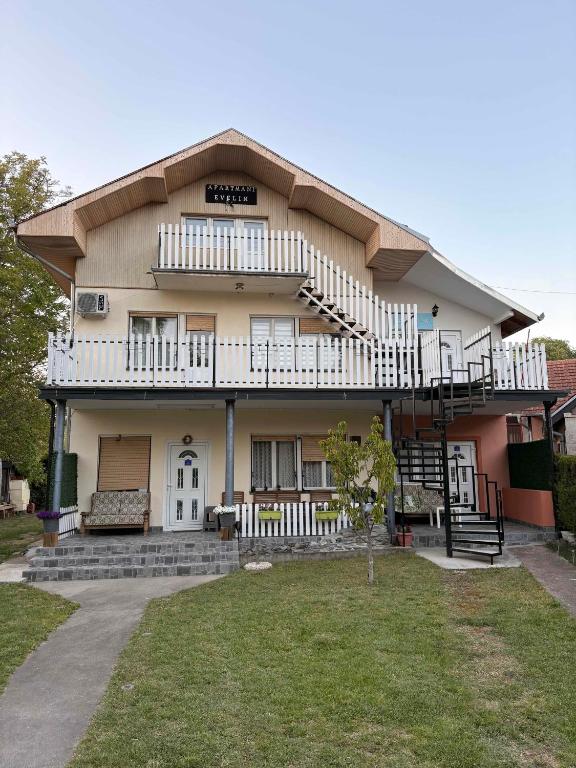 a large house with a balcony and a yard at Apartmani Evelin 1 in Veliko Gradište