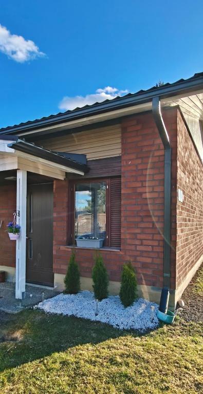 a brick house with a front door and some plants at Sorvarinraitin sydän in Seinäjoki