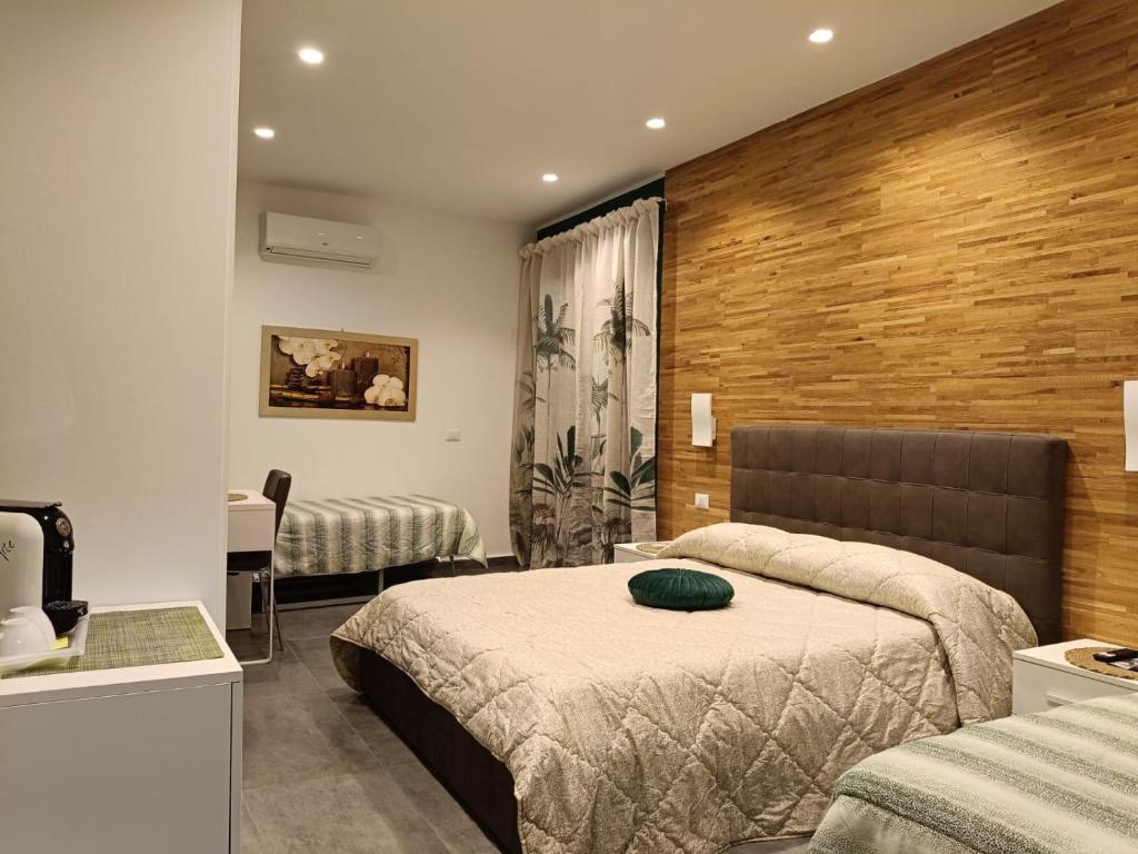 a hotel room with two beds and a television at B&B La Grotta in Nicolosi