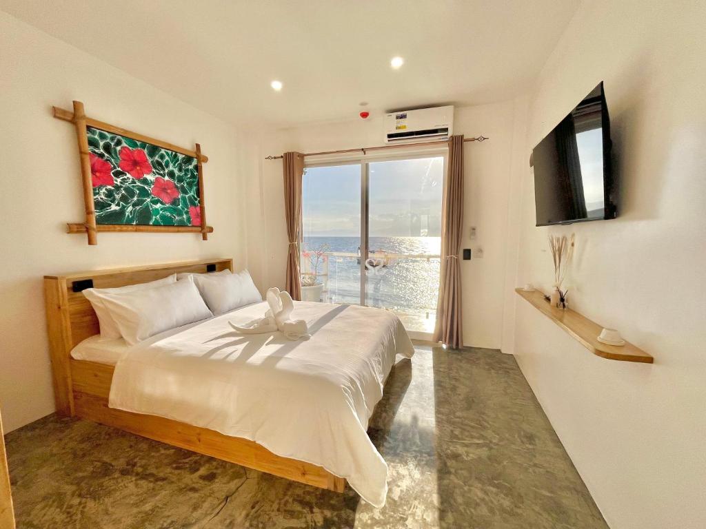a bedroom with a bed and a large window at Antuwanga reef resort in Moalboal
