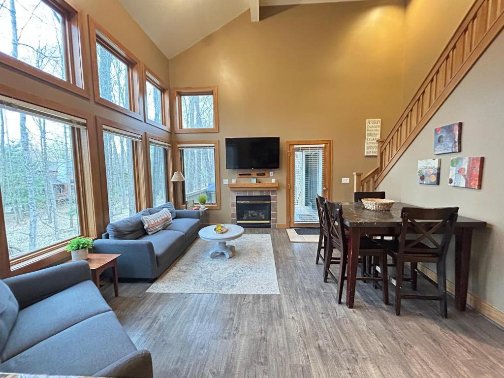 a living room with a couch and a table at Ski-In 5BR Retreat at Boyne Mtn - Walk to Lifts & Fun! in Boyne Falls